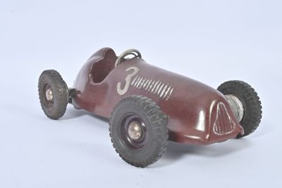 a red toy car with wheels on a white surface