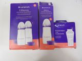 two boxes of baby bottles sitting on top of a white table