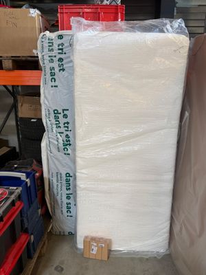 a large pile of mattresses in a warehouse