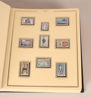 un livre ouvert sur lequel sont collés plusieurs timbres