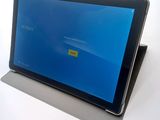 a tablet with a blue screen sitting on top of a table