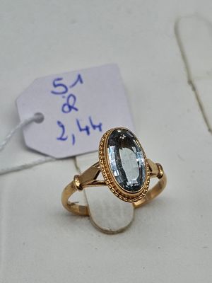an image of a gold ring with a blue topaz stone