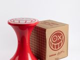 a red table with a box and a red candle holder