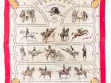 L'écharpe est rouge et blanche, avec des chevaux et des jockeys dessinés dessus.
