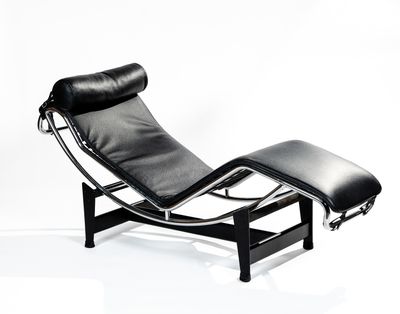 black leather chaise lounger and ottoman on a white background