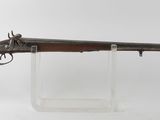 un fusil avec un canon en bois sur un support transparent