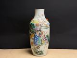 un vase avec un tableau posé sur une table