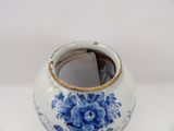 a blue and white vase sitting on a white surface