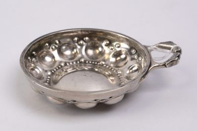 an image of a silver bowl with a handle on a white surface