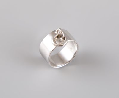un gros plan d'une bague en argent avec un nœud au milieu