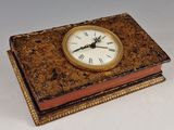 une horloge posée sur un livre, sur une table
