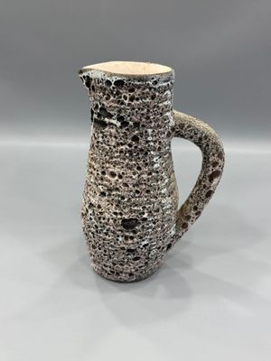 un gros plan d'un vase posé sur une table, sur fond gris