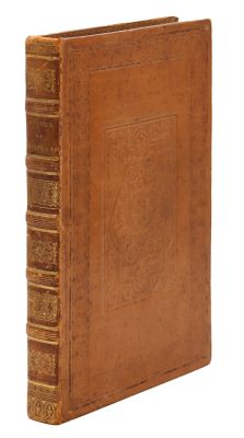 un vieux livre à la couverture brune posé sur une surface blanche