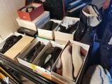 de nombreuses paires de chaussures dans des cartons posés sur un piano