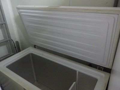 un réfrigérateur blanc dont la porte est ouverte, dans une pièce