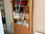 une armoire en bois sur laquelle sont posés de nombreux objets, dans la pièce