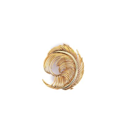 un gros plan d'une broche dorée sur fond blanc