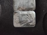 a metal case with needles in it on a black cloth