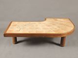 une table basse en bois avec un plateau en carrelage sur fond gris