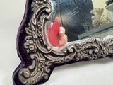 a mirror that has a hand holding a red object in it