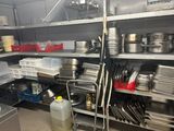 de nombreuses casseroles et poêles sur les étagères de la cuisine