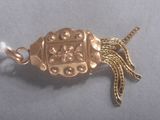 a gold colored brooch with a tassel on it