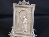 an old silver picture frame with a picture of a man holding a cross