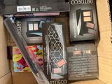 a cardboard box filled with makeup and cosmetics items