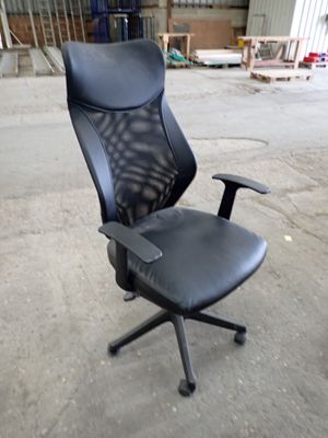 une chaise de bureau noire posée au milieu de la pièce
