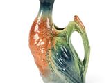 a bird shaped vase with a handle on a white surface