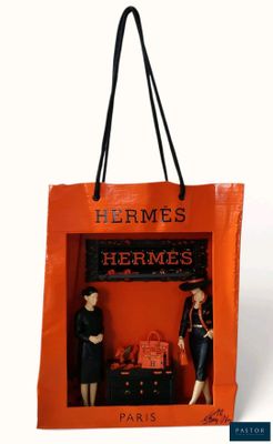 an orange shopping bag with two mannequins in it