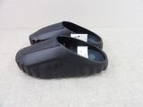 a pair of black clogs that are on the ground