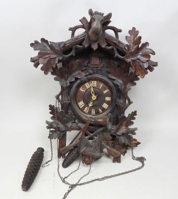 une horloge accrochée au mur à côté d'une pomme de pin