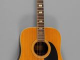 a close up of an acoustic guitar on a gray background