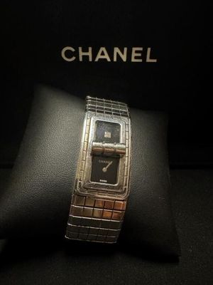 montre Chanel exposée devant un écrin noir