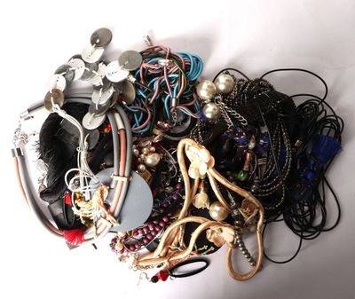 a pile of assorted jewelry on a white surface