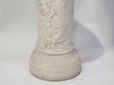 a white vase with a statue of a man and a woman on it