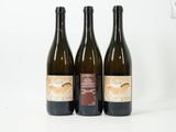 trois bouteilles de vin posées l'une à côté de l'autre sur une table