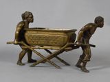 a bronze statue of two men pulling a tub