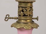 a pink vase with a white ball on top of it
