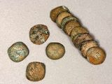 several pieces of ancient roman coins sitting on top of a white surface