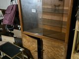 un meuble en bois avec une porte en verre au milieu d'une pièce