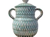 a blue and white vase with a lid on a white background