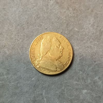 gros plan d'une pièce d'or sur une surface grise