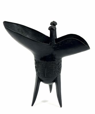 an image of a black sculpture of a bird on a stand