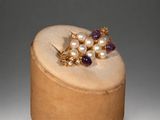 an image of a wooden box with a pair of earrings on top of it