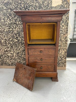 une vieille armoire en bois sur laquelle est posée une petite boîte en bois