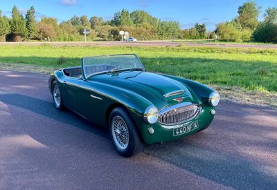 une photo d'une voiture de sport verte garée sur le bord de la route