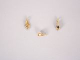 two gold earrings with black stones on them on a white surface