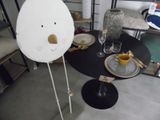une table sur laquelle sont posés des assiettes et des verres, avec un visage en papier
